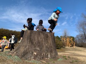 切り株から飛び降りる子ども